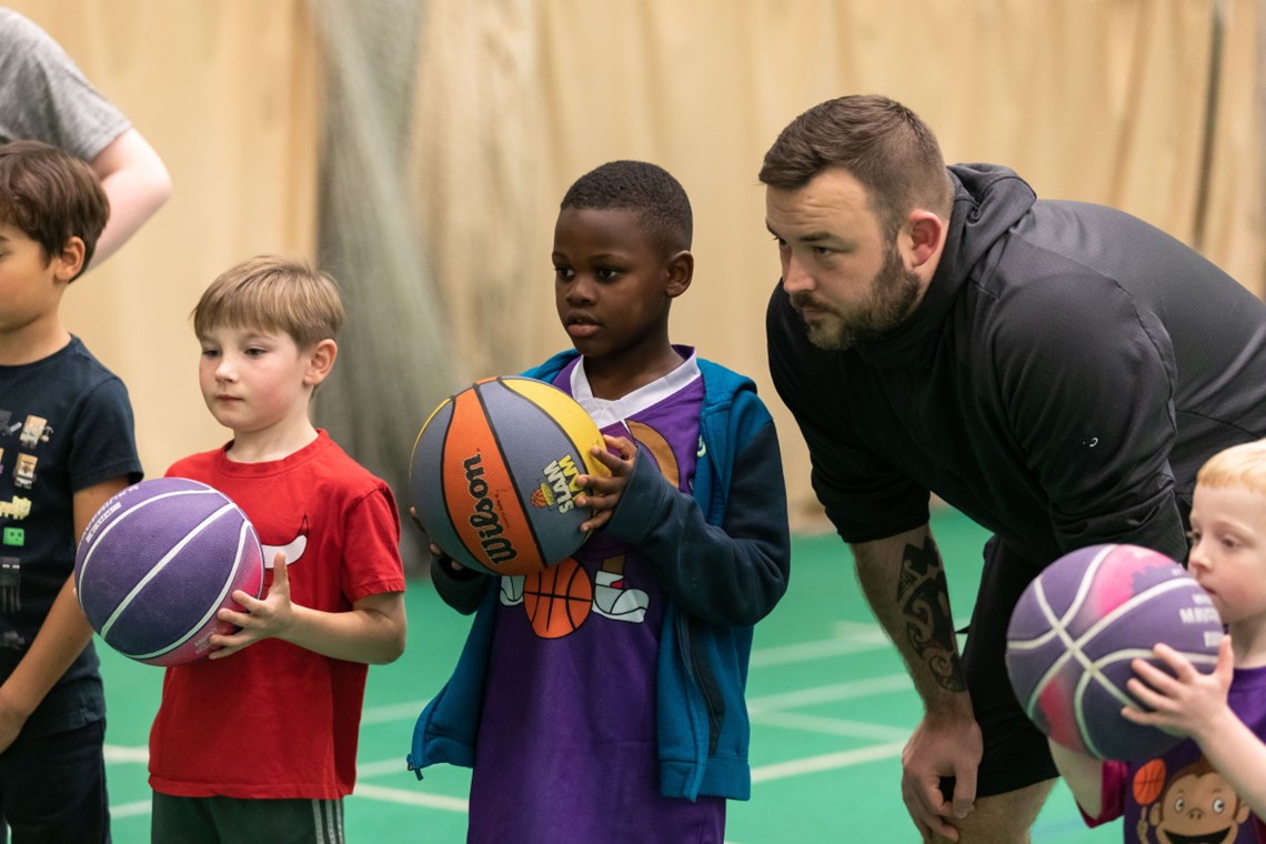 Photograph of boys holding basketballs in a children's basketball session